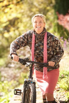 Portrait Of Young Woman With Cycle In Autumn Park