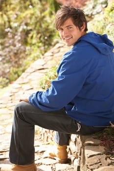 Young Man Relaxing In Autumn Garden
