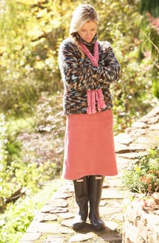 Full Length Portrait Of Young Woman Walking In Autumn Garden