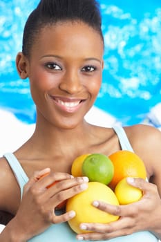 Young Woman Holding Citrus Fruit In Studio