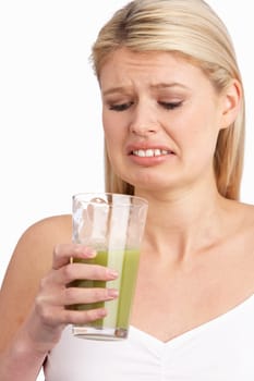 Young Woman Not Enjoying Healthy Drink In Studio