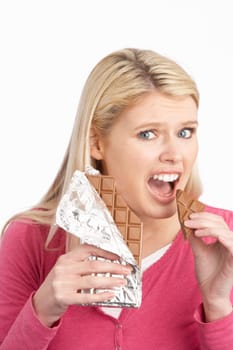Guilty Looking Young Woman Eating Big Bar Of Chocolate In Studio