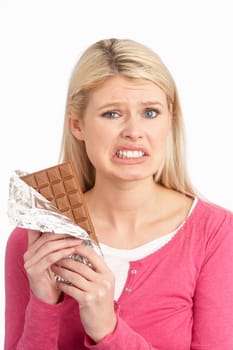Guilty Looking Young Woman Eating Big Bar Of Chocolate In Studio