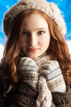 Teenage Girl Wearing Warm Winter Clothes And Hat In Studio