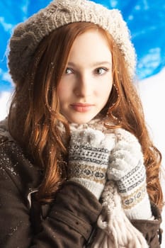 Teenage Girl Wearing Warm Winter Clothes And Hat In Studio
