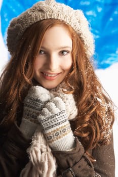 Teenage Girl Wearing Warm Winter Clothes And Hat In Studio