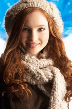 Teenage Girl Wearing Warm Winter Clothes And Hat In Studio