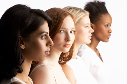 Portrait Of Four Attractive Young Women In Studio Standing In Line