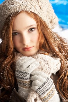 Teenage Girl Wearing Warm Winter Clothes And Hat In Studio