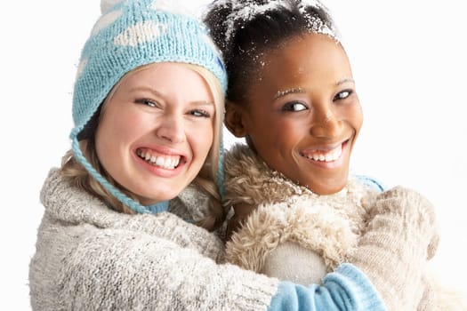 Two Young Women Wearing Warm Winter Clothes Holding Snowball In Studio