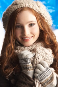 Teenage Girl Wearing Warm Winter Clothes And Hat In Studio