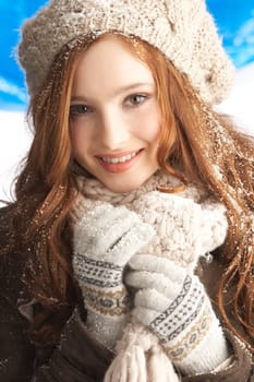 Teenage Girl Wearing Warm Winter Clothes And Hat In Studio