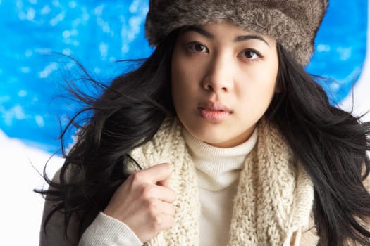 Young Woman Wearing Warm Winter Clothes And Fur Hat In Studio