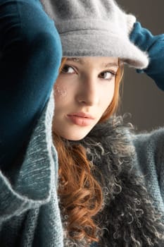 Fashionable Teenage Girl Wearing Cap And Knitwear In Studio