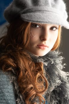 Fashionable Teenage Girl Wearing Cap And Knitwear In Studio