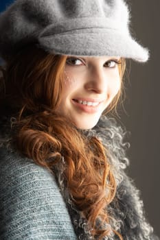 Fashionable Teenage Girl Wearing Cap And Knitwear In Studio