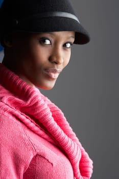 Fashionable Young Woman Wearing Cap And Knitwear In Studio