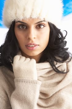 Young Woman Wearing Warm Winter Clothes And Fur Hat In Studio