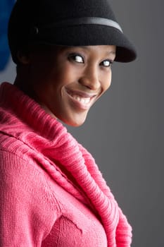 Fashionable Young Woman Wearing Cap And Knitwear In Studio