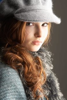 Fashionable Teenage Girl Wearing Cap And Knitwear In Studio