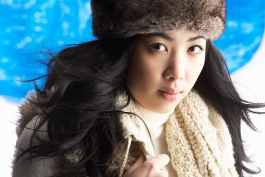 Young Woman Wearing Warm Winter Clothes And Fur Hat In Studio