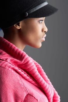 Fashionable Young Woman Wearing Cap And Knitwear In Studio