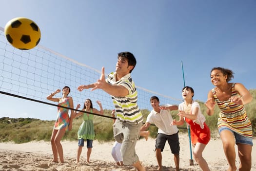 Group Of Teenage Friends Playing Volleyball On Beach