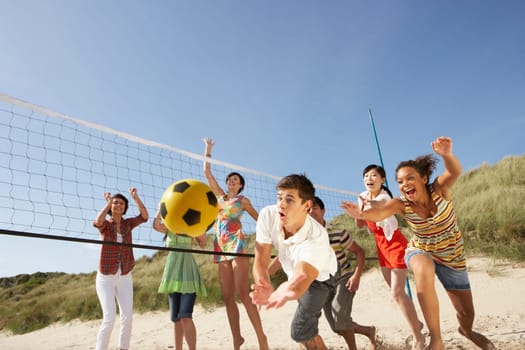 Group Of Teenage Friends Playing Volleyball On Beach