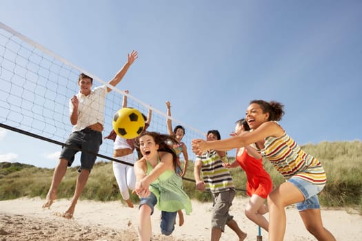 Group Of Teenage Friends Playing Volleyball On Beach