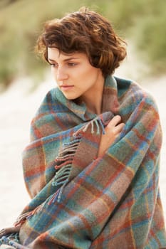 Young Woman Standing In Sand Dunes Wrapped In Blanket