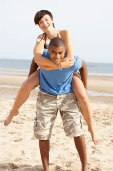 Young Couple Having Piggyback Fun On Beach