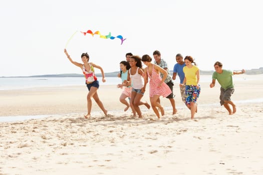 Group Of Friends Running Along Beach Together