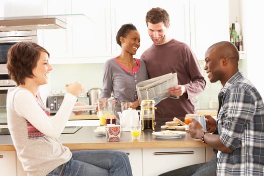 Group Of Young Friends Preparing Breakfast In Modern Kitchen