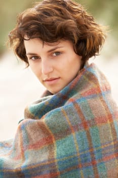 Young Woman Standing In Sand Dunes Wrapped In Blanket