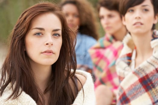 Close Up Of Group Of Girls Sitting On Beach Together