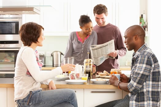 Group Of Young Friends Preparing Breakfast In Modern Kitchen