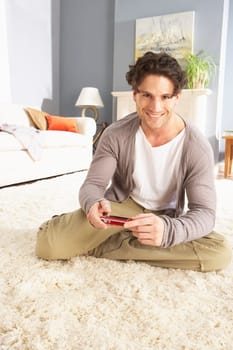 Young Man Looking At Photograph On Digital Camera At Home