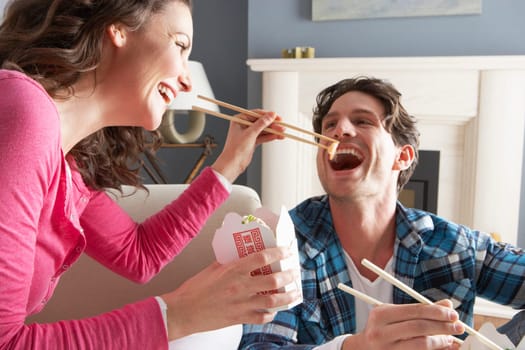 Couple Enjoying Chinese Takeaway Meal At Home