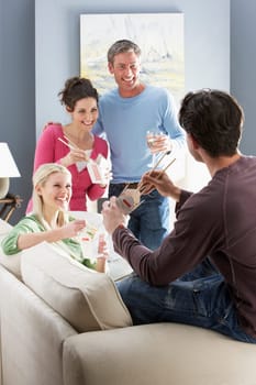 Group Of Friends Enjoying Chinese Takeaway Meal At Home