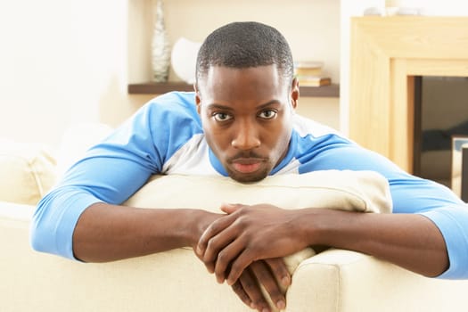 Man Relaxing On Sofa At Home
