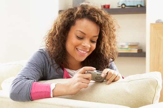 Woman Looking At Pictures On Digital Camera Relaxing Sitting On Sofa At Home