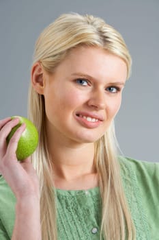 Woman Relaxing On Sofa Eating Apple At Home