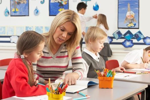 Group Of Primary Schoolchildren And Teacher Having lesson In Classroom