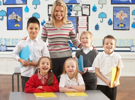 Portrait Of Group Of Primary Schoolchildren And Teacher Sitting At Desk In Classroom