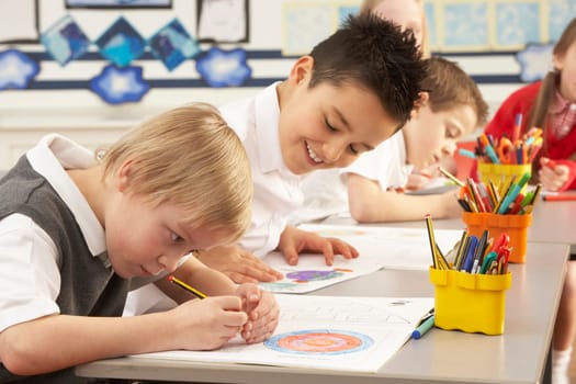 Group Of Primary Schoolchildren In Classroom Working At Desks