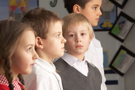 Portrait Of Group Of Primary Schoolchildren Standing In Classroom