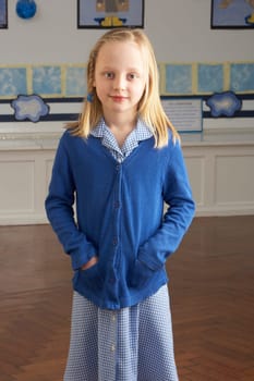 Portrait Of Female Primary School Pupil Standing In Classroom