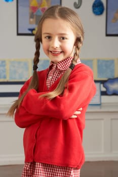 Portrait Of Female Primary School Pupil Standing In Classroom