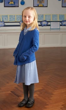 Portrait Of Female Primary School Pupil Standing In Classroom