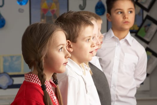 Portrait Of Group Of Primary Schoolchildren Standing In Classroom